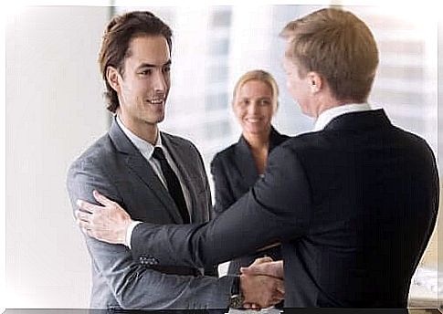 Two men in suits shake hands