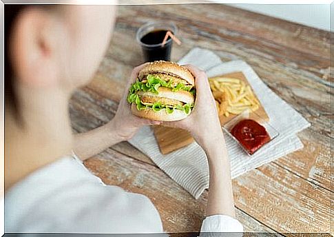 Woman with emotional hunger eats fast food