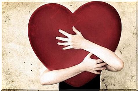 Woman clutches a heart as an example of unhealthy emotional dependence