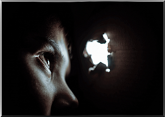 Boy looking through a hole in a box and suffering from separation anxiety