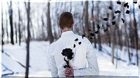 Man holds black rose behind his back