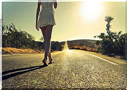 Woman Walking Barefoot Down A Road